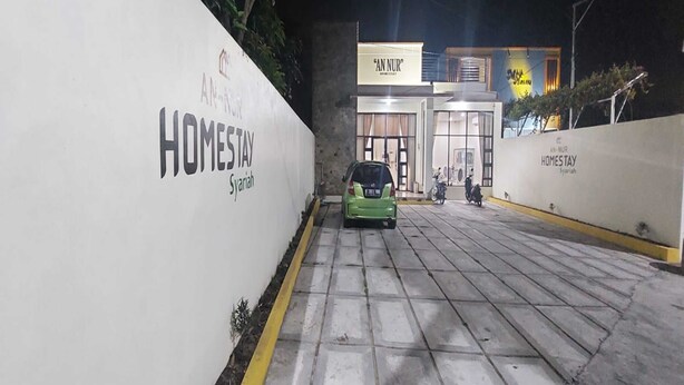 A gated entrance to a property named "An-Nur Homestay" with a green car parked in front. - Capital O 93489 An Nur Homestay Syariah (Mungkid)