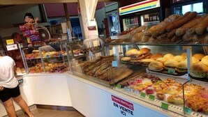 A bakery display case with various baked goods and a sign indicating items for sale. - Tartane Beach SPA 2 MER (La Trinité)
