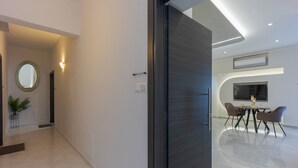 Un interior moderno con un vidrio que da a un comedor con mesa y sillas.