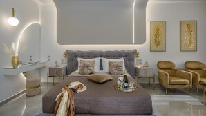 Un dormitorio moderno con una cama grande, mesitas de noche, un tocador y dos sillas.