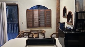 Una cocina compacta con estufa, cafetera y armarios de madera.