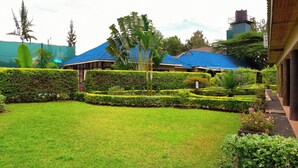A well-maintained garden with a lawn, hedges, and various plants. - Blixen Resort & Spa  (Nairobi)