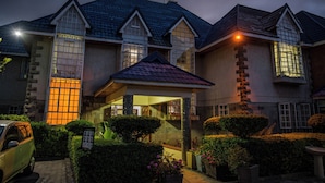 A large, multi-story house with a prominent entrance, stone pillars, and a well-maintained garden. - Blixen Resort & Spa  (Nairobi)