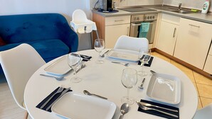 Una mesa de comedor dispuesta con platos, vasos, cubiertos y una bandeja.