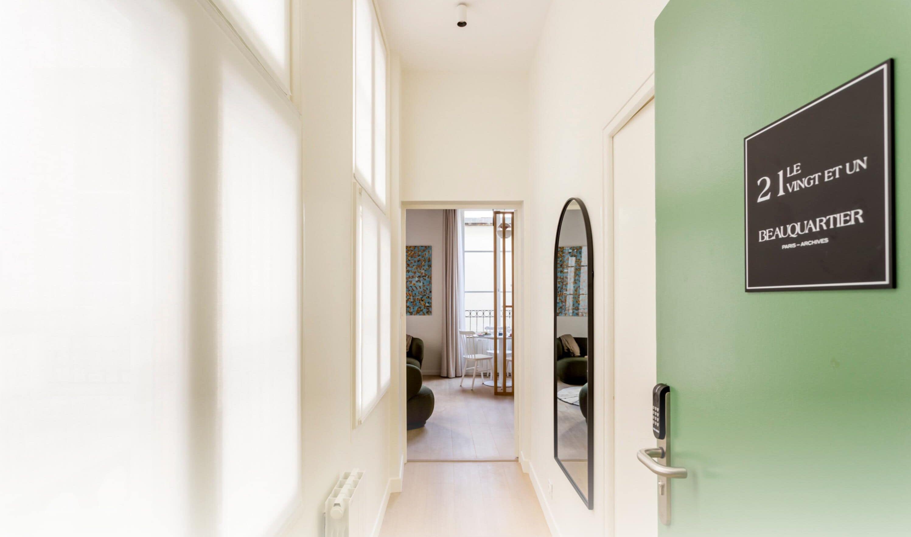 A hallway with a door on the right displaying a sign for "Le 21 Vingt et Un Beauquartier Paris - Archives."