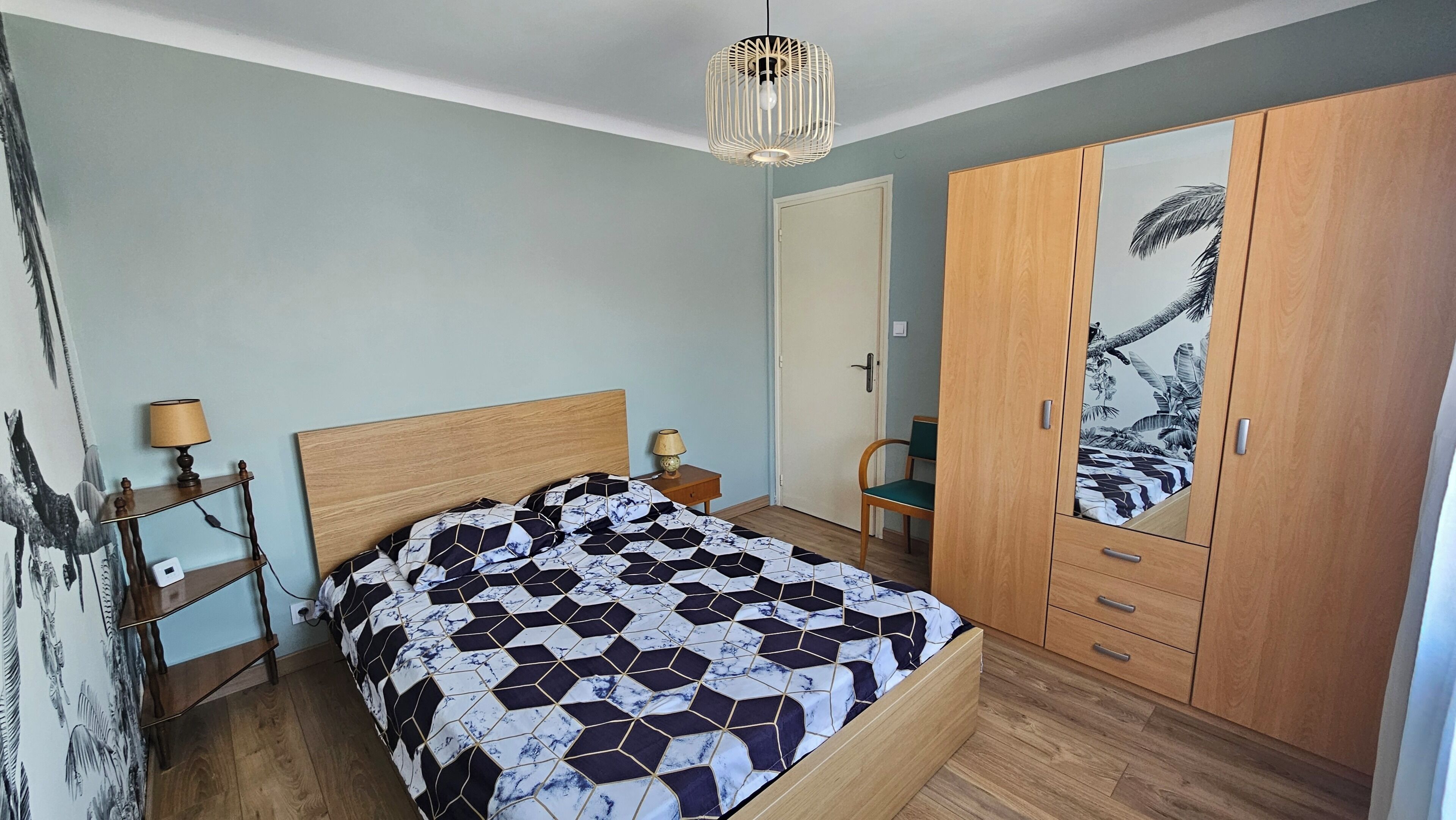 Un dormitorio con cama, armario de madera y una pared decorada con un cuadro.