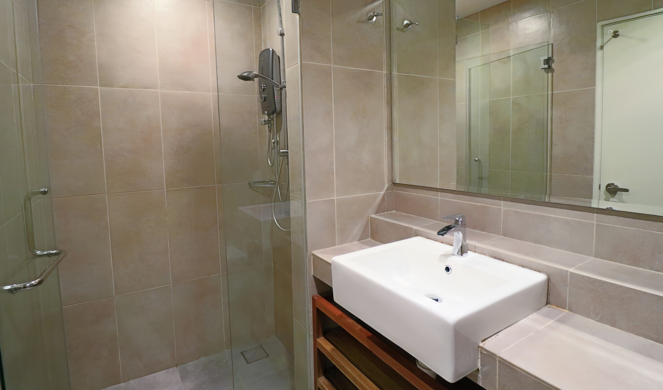 A modern bathroom with a glass shower enclosure, a white sink, and a large mirror.
