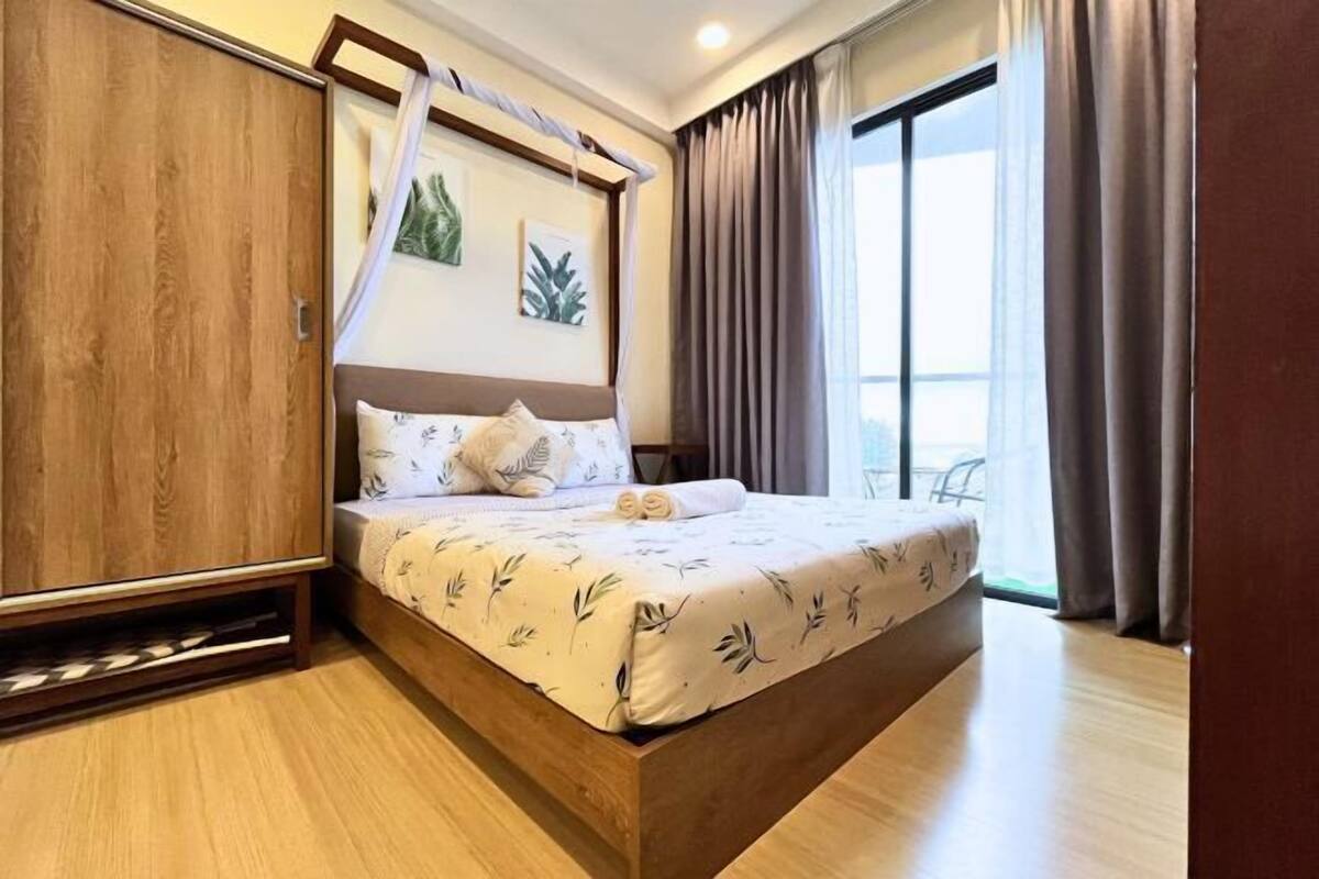 Une chambre à coucher avec un lit, une armoire et une fenêtre avec des rideaux.