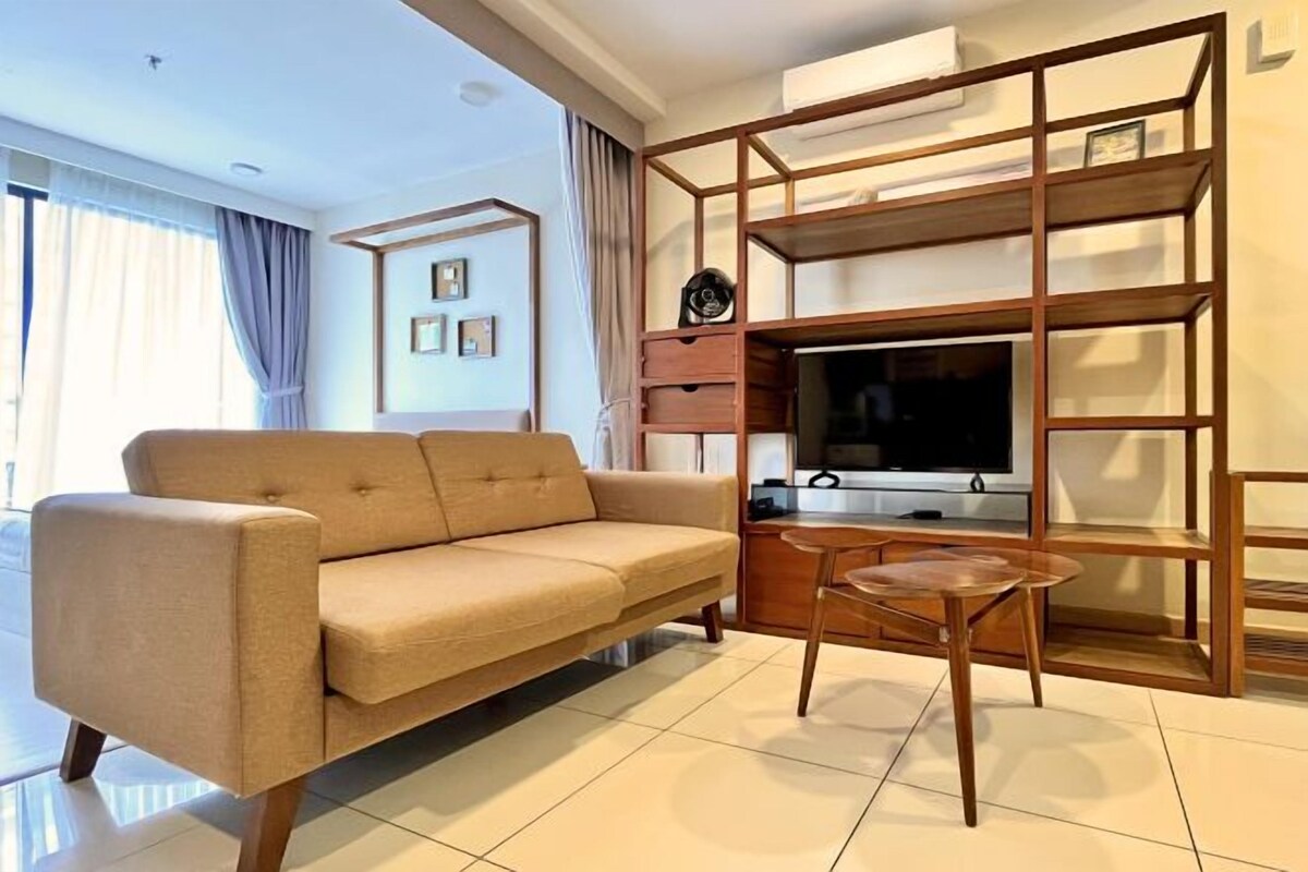 A modern living room with a sofa, a coffee table, and a TV.