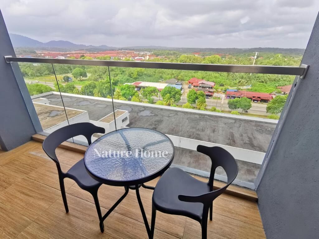 Un balcón con una mesa redonda y sillas, con vistas a una zona residencial con casas y vegetación.