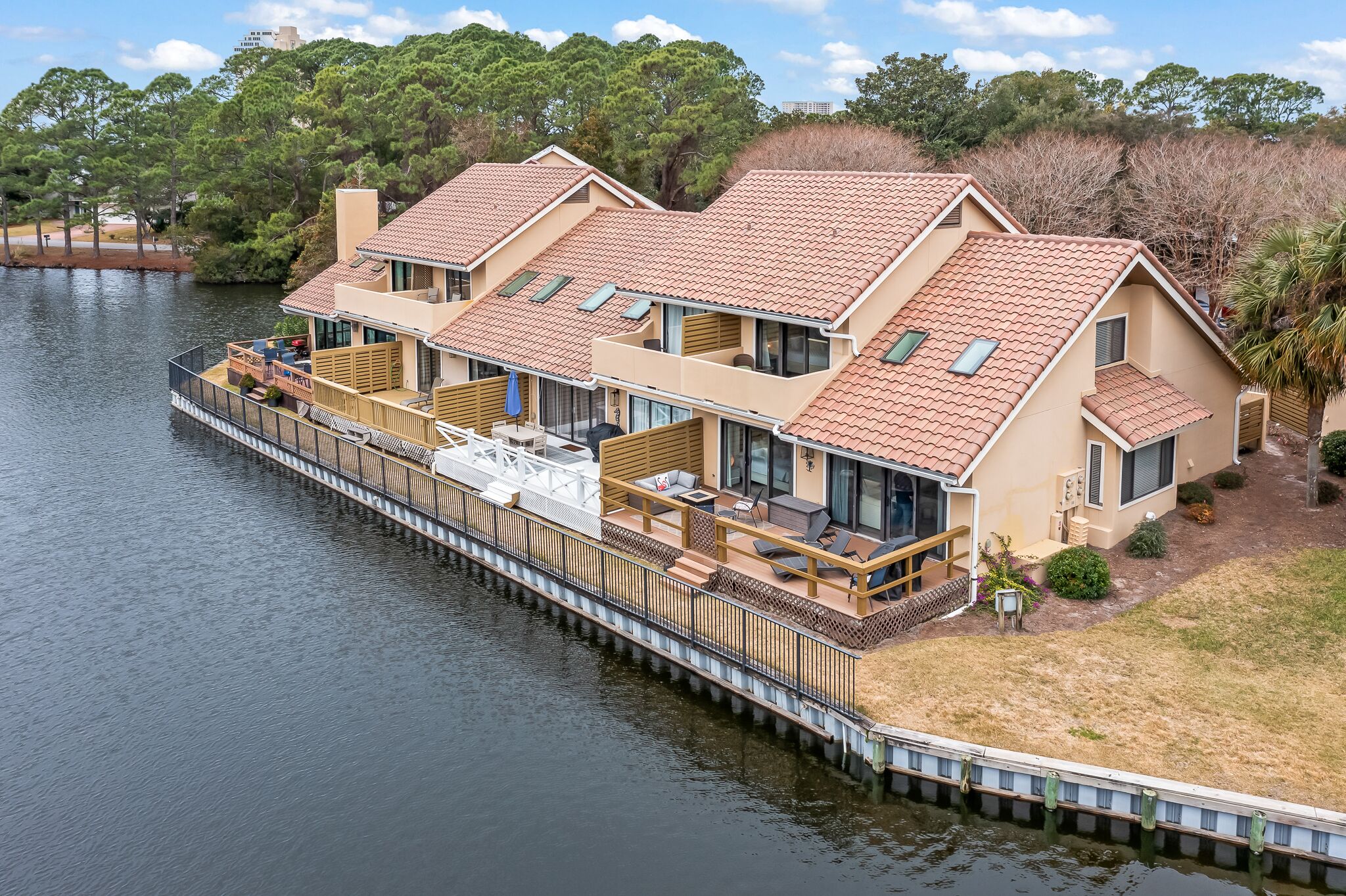 A waterfront property with a dock, multiple decks, and a large outdoor seating area.