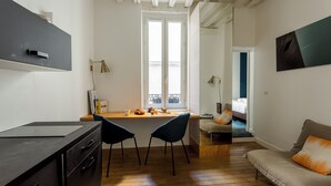 Un espacio habitable compacto con kitchenette, comedor y sofá.