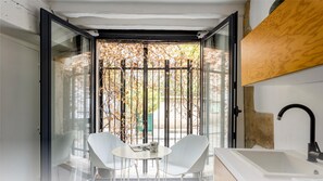 A modern bathroom with a glass door, a white sink, and a black faucet. - Beauquartier - Marais Vertus (Paris)