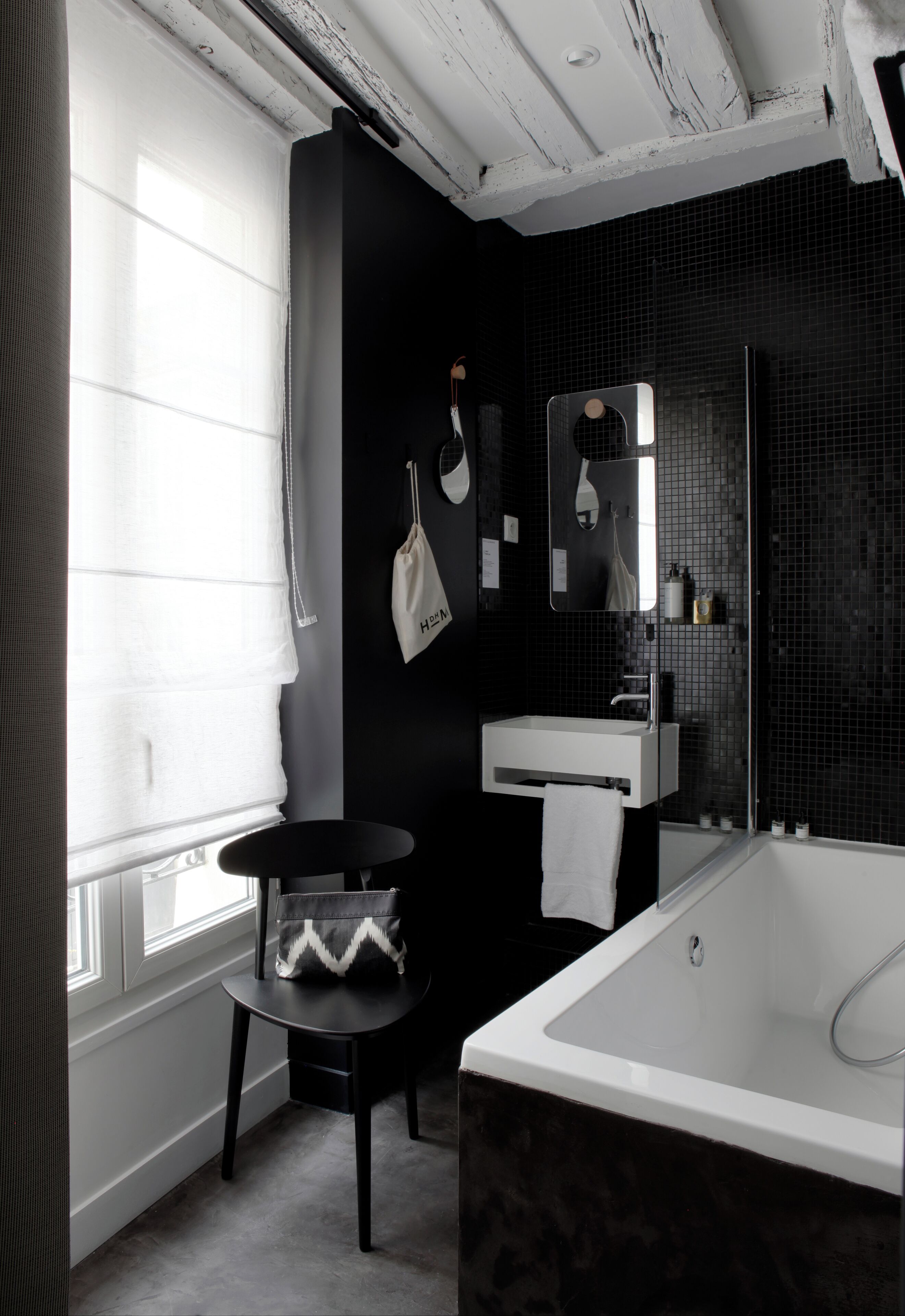 A modern bathroom with a large bathtub, a white sink, and a mirror.