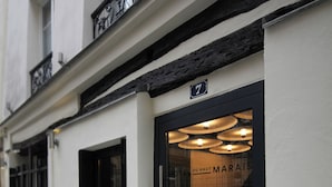 Fachada de edificio con un ventanal de marco negro y un letrero encima.
