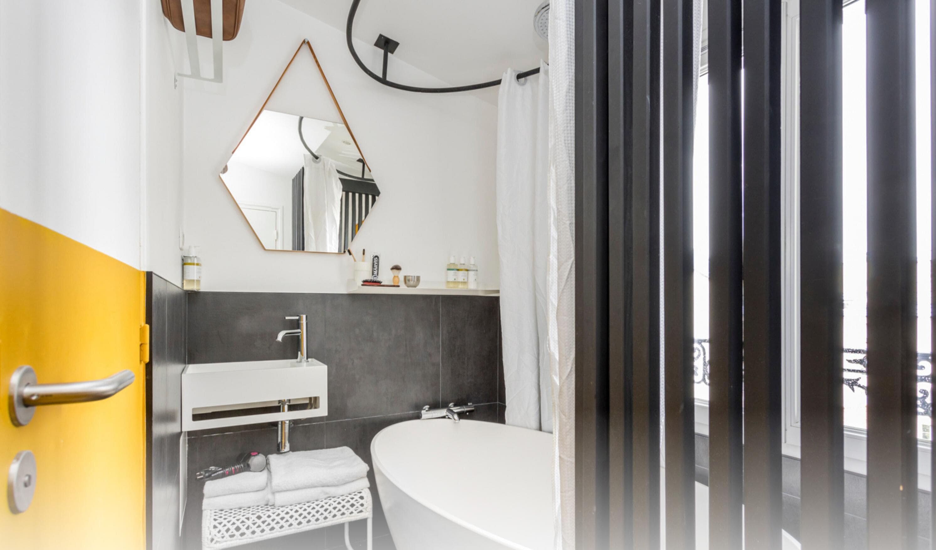 A modern bathroom with a white sink, a large mirror, and a bathtub.