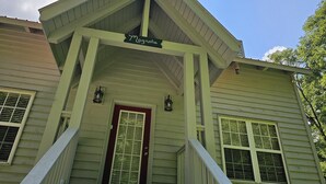 A house with a porch, a red door, and a sign that reads "Magnolia." - Magnolia-Cabin sits on Coosa creek with a breath taking view of the falls (Blairsville)