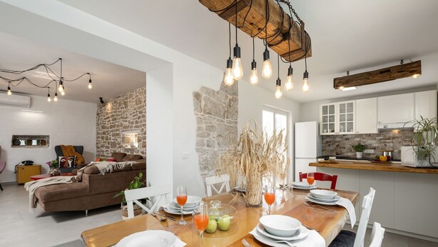 A modern kitchen with white cabinets, a wooden countertop, and a stone wall. - Villa Corinna (Istria - Poreč) (Poreč)