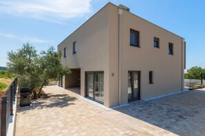 Un bâtiment moderne à deux étages, doté d’un toit plat, de grandes fenêtres en verre et d’une allée pavée.