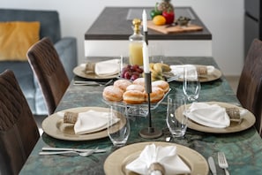 Enjoy a meal at this beautifully set table with a delicious spread of pastries, fresh fruit, and refreshing drinks.