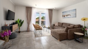 A modern living room with a sofa, TV, and a painting of a lighthouse.
