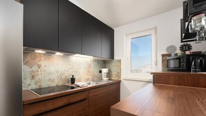 A modern kitchen with dark cabinets, a wooden countertop, and a coffee machine. - Apartment Vanilla Sky (Istria - Poreč) (Poreč)
