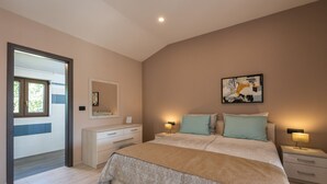 Een slaapkamer met een bed, nachtkastjes, een dressoir, een spiegel en een schilderij aan de muur.