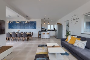 Una sala de estar moderna con un sofá, una mesa de centro y un comedor.