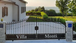 Une entrée fermée par un portail sur lequel on peut lire les mots « Villa » et « Monti ».