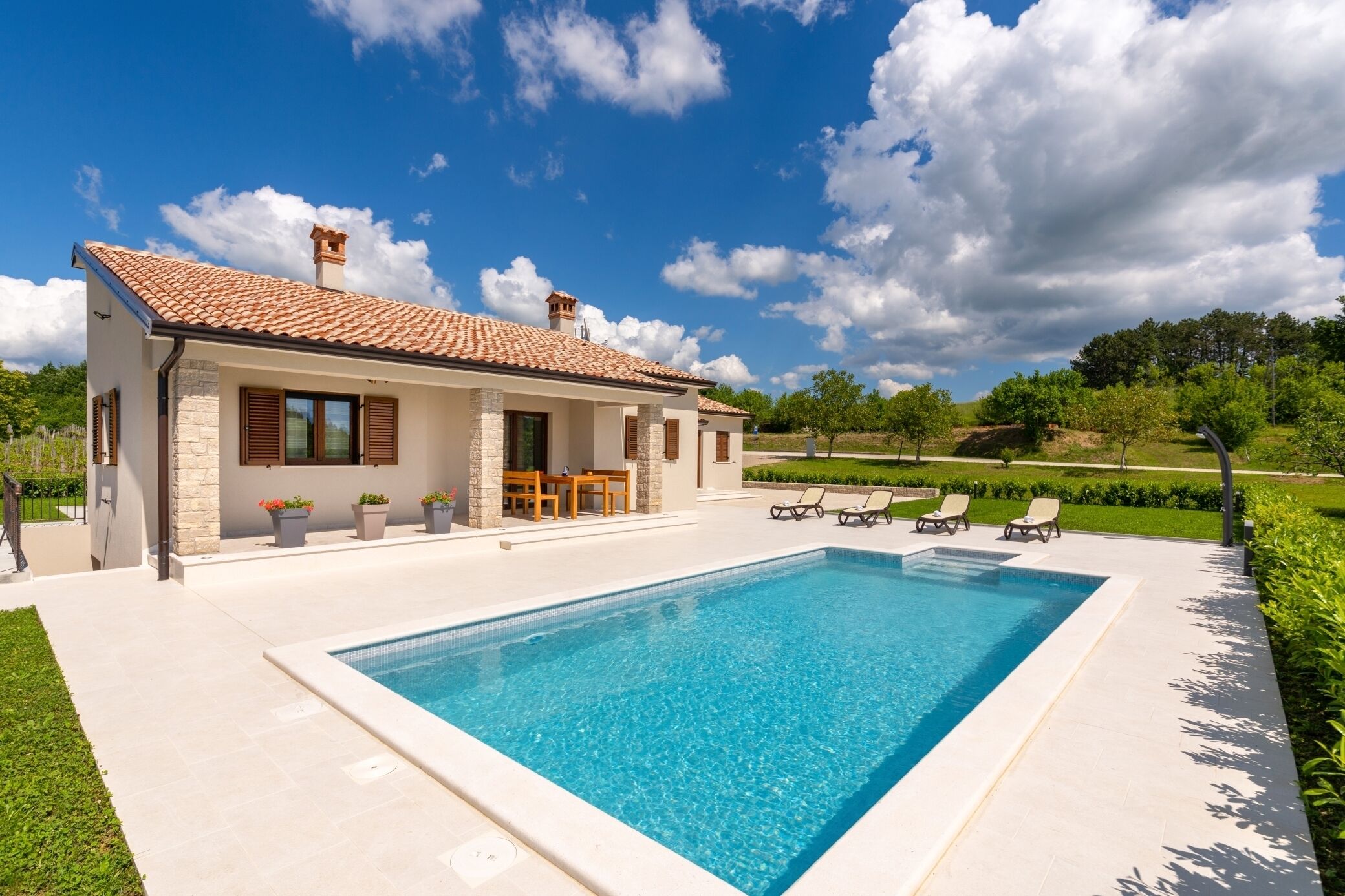 A modern house with a swimming pool, outdoor furniture, and a well-maintained garden.