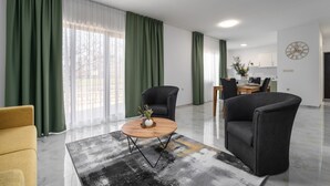 A modern living room with a sofa, two armchairs, a coffee table, and a dining area with a table and chairs. - Villa Demetra (Istria - Tinjan) (Tinjan)