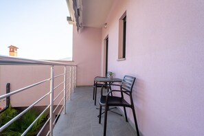 A balcony with a metal railing, two chairs, a small table, and a potted plant. - Apartment Astrid 1 (Istria - Labin) (Labin)