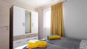 A bedroom with a bed, a wardrobe, and a window with curtains. - Apartment Ulika (Istria - Visnjan) (Visnjan)