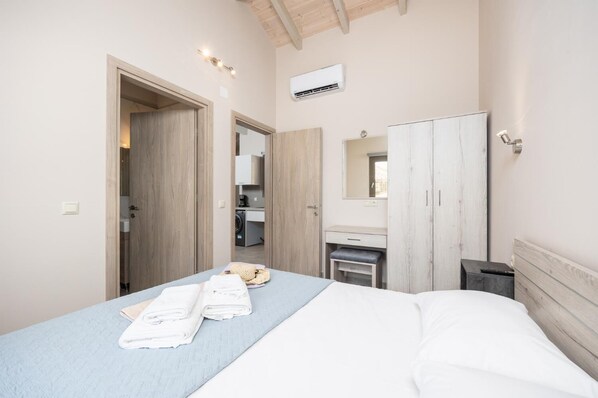 Ein Schlafzimmer mit einem Bett, einem Kleiderschrank, einem Spiegel und einem kleinen Schreibtisch mit Stuhl.