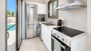 Een moderne keuken met een roestvrijstalen koelkast, een inbouwoven en een zwart inductiekookplaat.