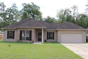 A single-story house with a brick facade, a front porch, and a garage.