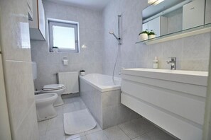 Een douche, een haardroger, pantoffels, handdoeken