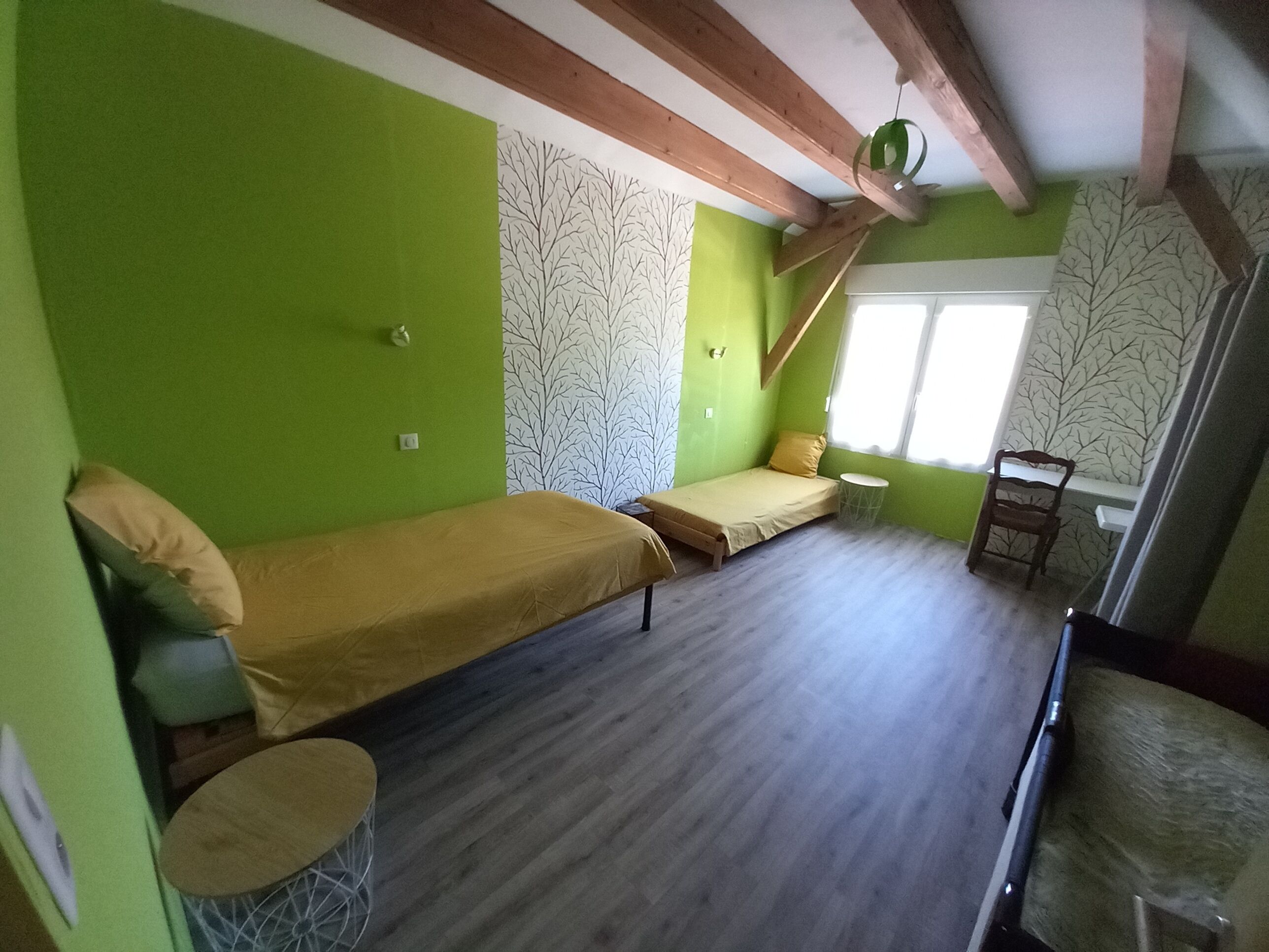 A room with a bed, a small table, and a window.