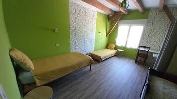 A room with a bed, a small table, and a window.