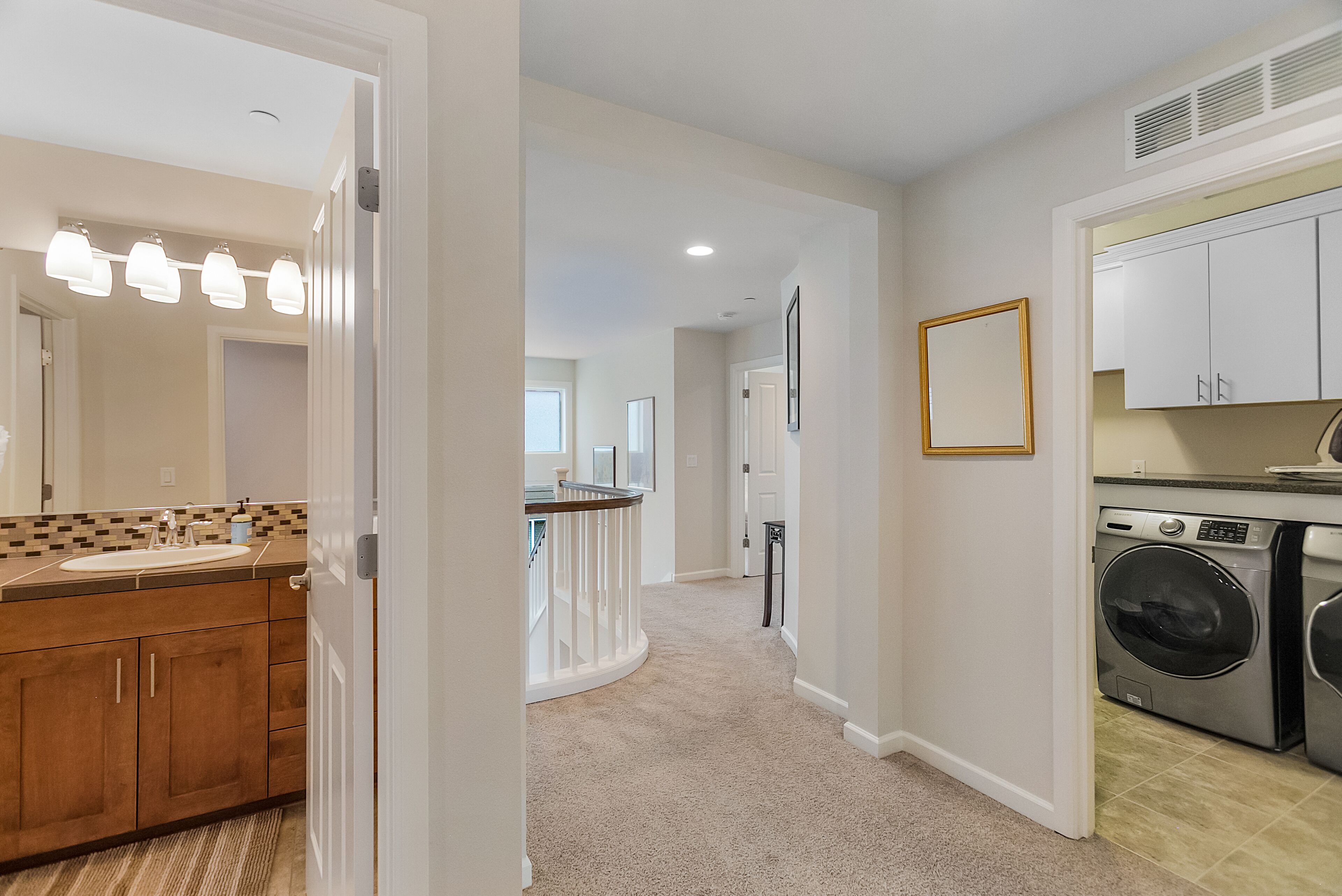 A modern kitchen with a built-in washer and dryer, a wooden countertop, and a view to the living area.