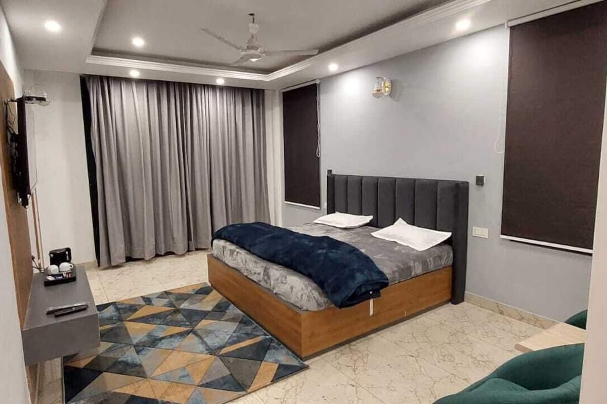 Un dormitorio moderno con cama, escritorio y silla.