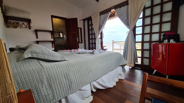 Une chambre à coucher avec un lit, une armoire rouge et une vue par la fenêtre.
