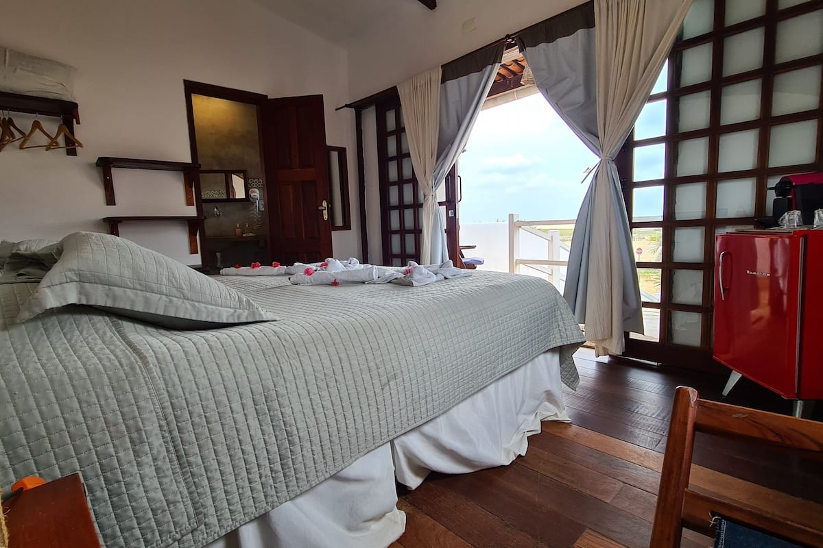Un dormitorio con una cama, un armario rojo y vistas por una ventana.