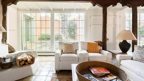 A cozy living room with a white sofa, a wicker basket with magazines, and a lamp. - Canyon Road Hacienda in Heart of Santa Fe (Santa Fe)