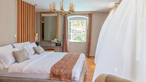 A bedroom with a large bed, a wooden panel wall, a mirror, and a window with curtains. - Luxury Pool Villa Feliz (Dražin Vrt)