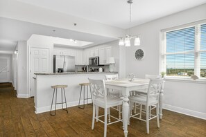 Enjoy meals in the kitchen with a central island, sink, and stainless steel appliances, adjacent to a dining area with a table and chairs.