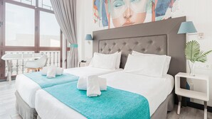 A hotel room with a large bed, a bedside table with a lamp, a window with curtains, and a wall with a colorful abstract painting. - Oh Nice Revellin Ceuta (Ceuta)