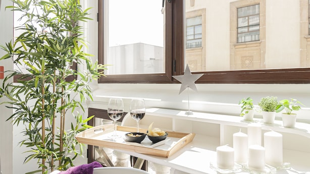 A dining table with a tray, two wine glasses, a bowl of pasta, and candles. - Oh Nice Revellin Ceuta (Ceuta)