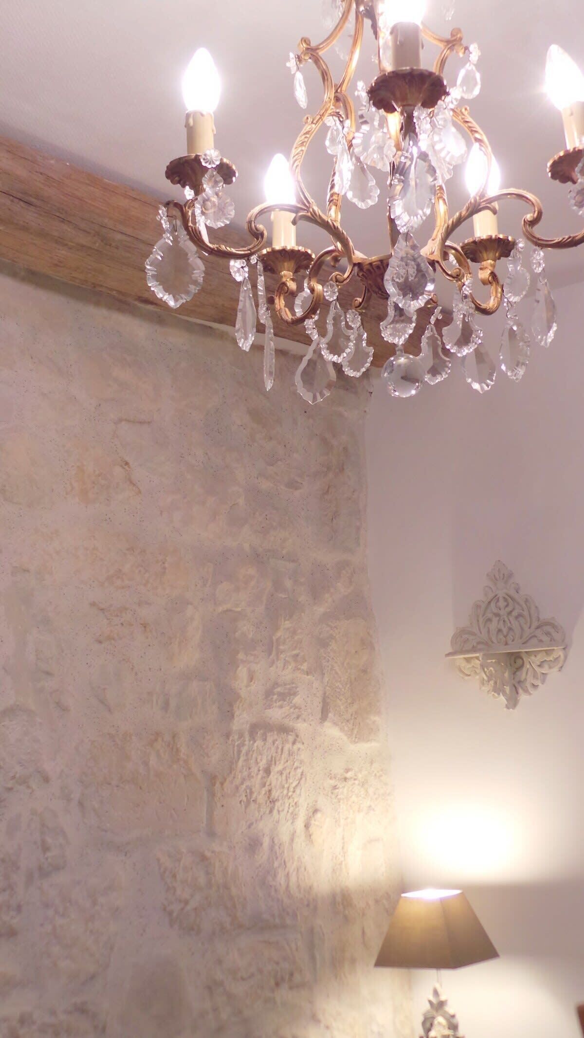 Un lustre orné de décorations en cristal et un mur en pierre.