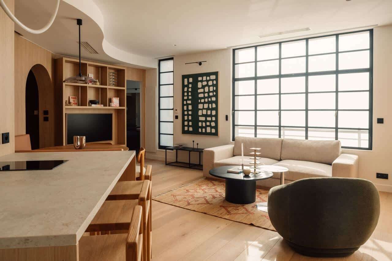 Ein modernes Wohnzimmer mit einer Couch, einem Couchtisch und einem Essbereich mit Stühlen und einem Tisch.